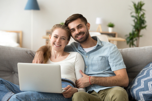 Couple sitting on couch with computer